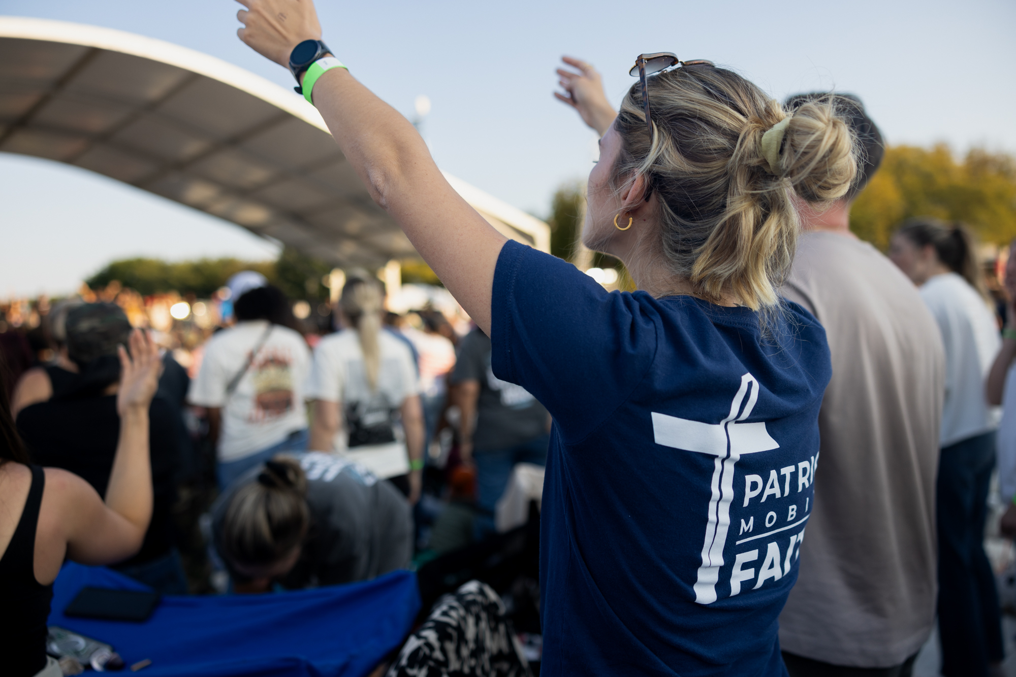 Patriot Mobile supporter raising her hand at an outdoor event