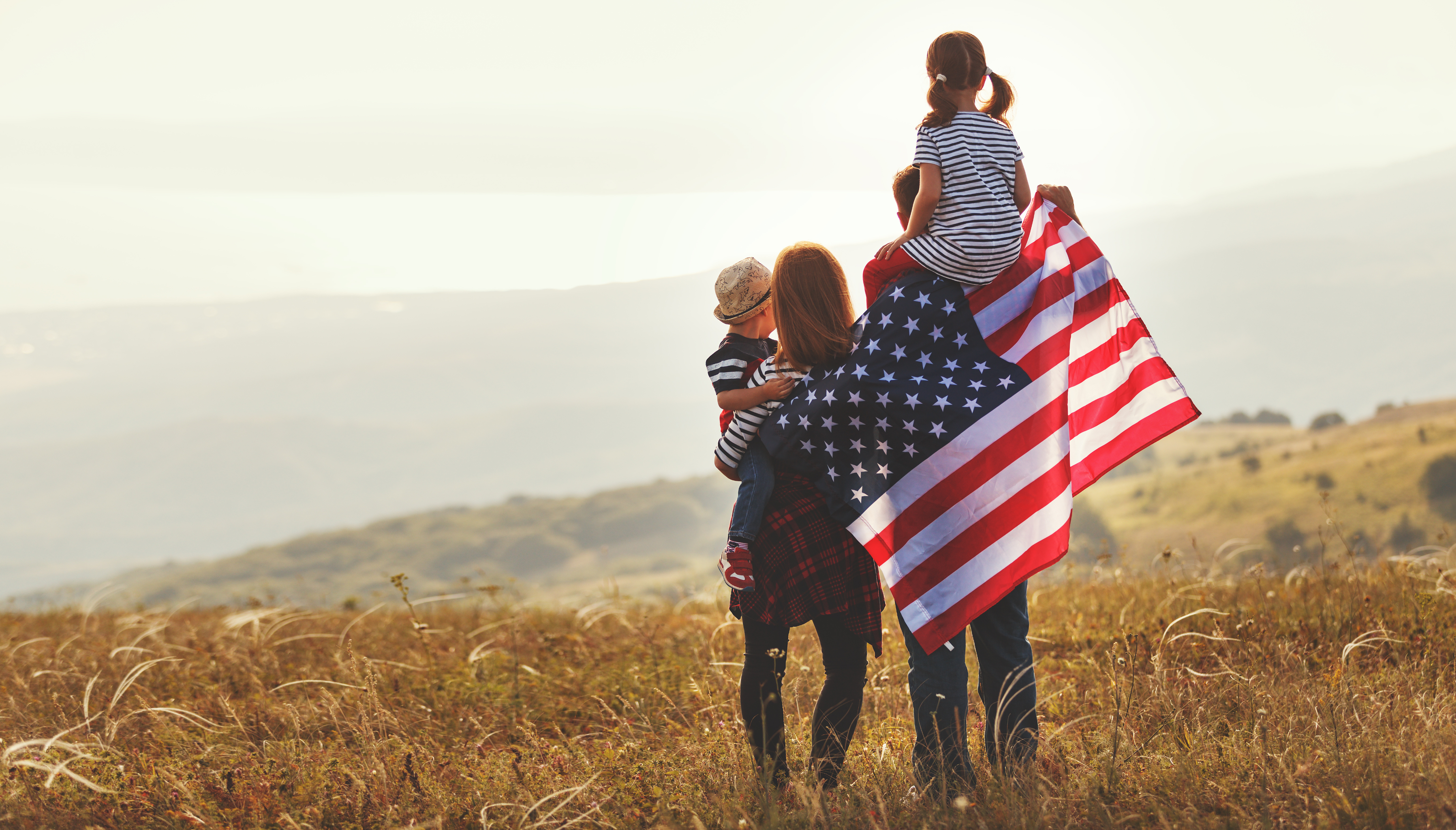 Family standing with an American flag